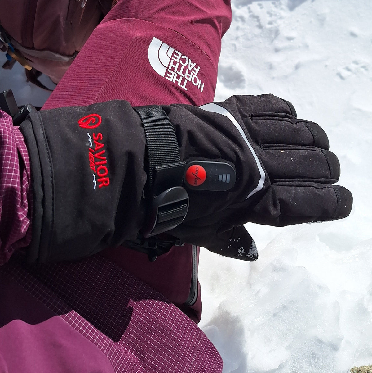Mountain climber wearing SAVIOR battery heated gloves at high altitude
