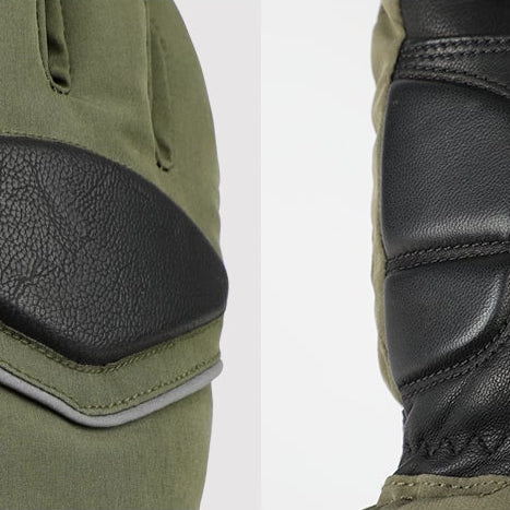 Close-up of reinforced leather padding on green heated gloves, showing durable stitching and protective design for skiing, cycling, and winter outdoor use.