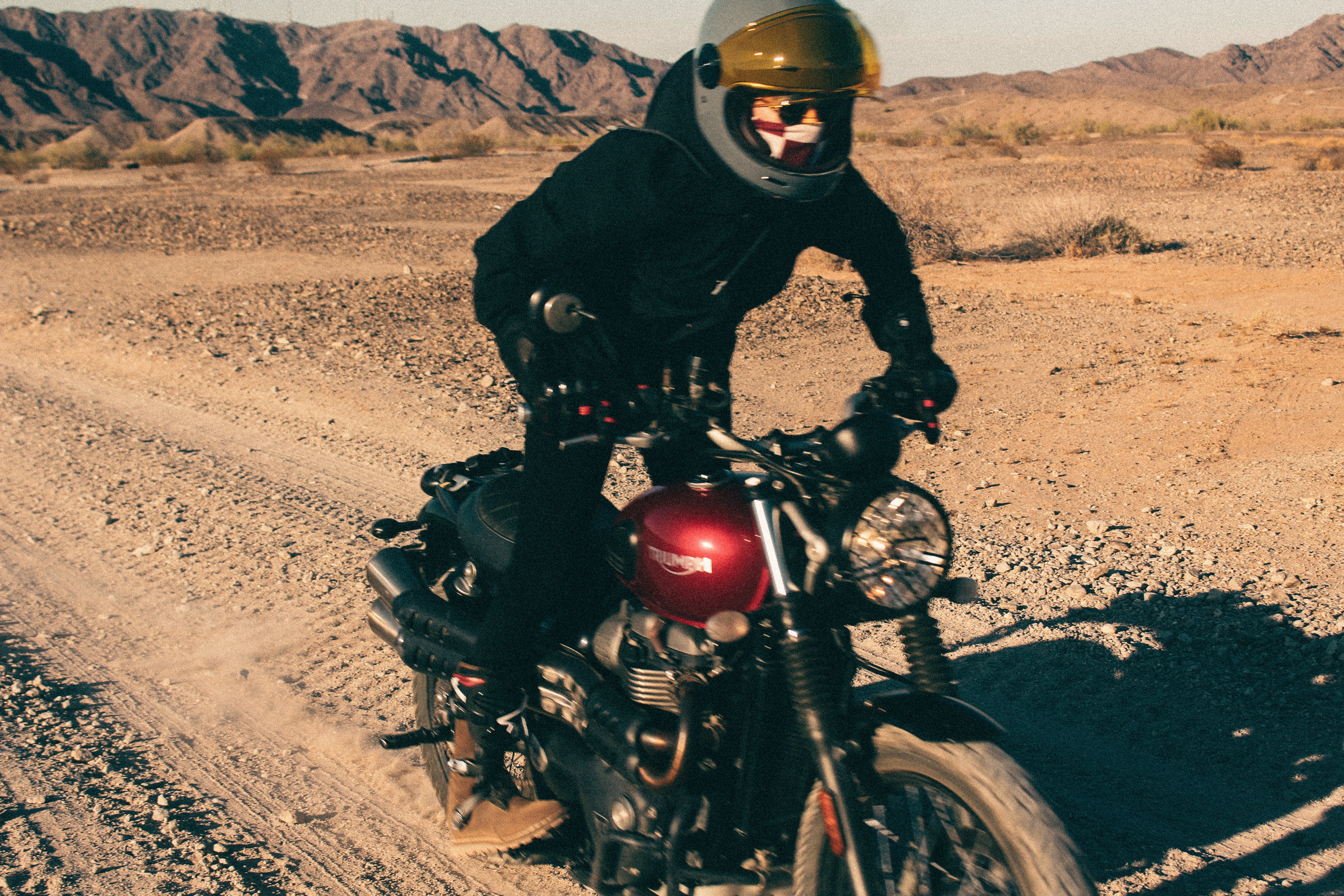 Rider adjusting a reflective motorcycle helmet while wearing heated protective gloves.