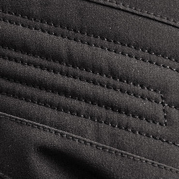 Close-up of black textured fabric featuring parallel reinforced stitching lines, enhancing durability and structural integrity for outdoor gear, apparel, or accessories.