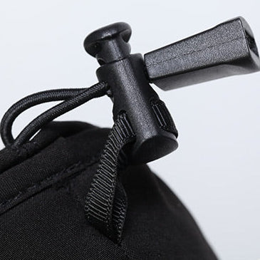 Adjustable black plastic toggle clamp (knob + clip) for fast, secure fastening and tension control on outdoor gear, bags, and apparel straps