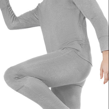 Person wearing gray heated underwear, showing flexible, close-fitting design during movement.