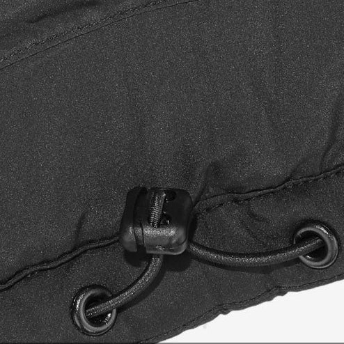 Close-up of black heated vest hem showing adjustable drawstring cord lock for a snug fit.