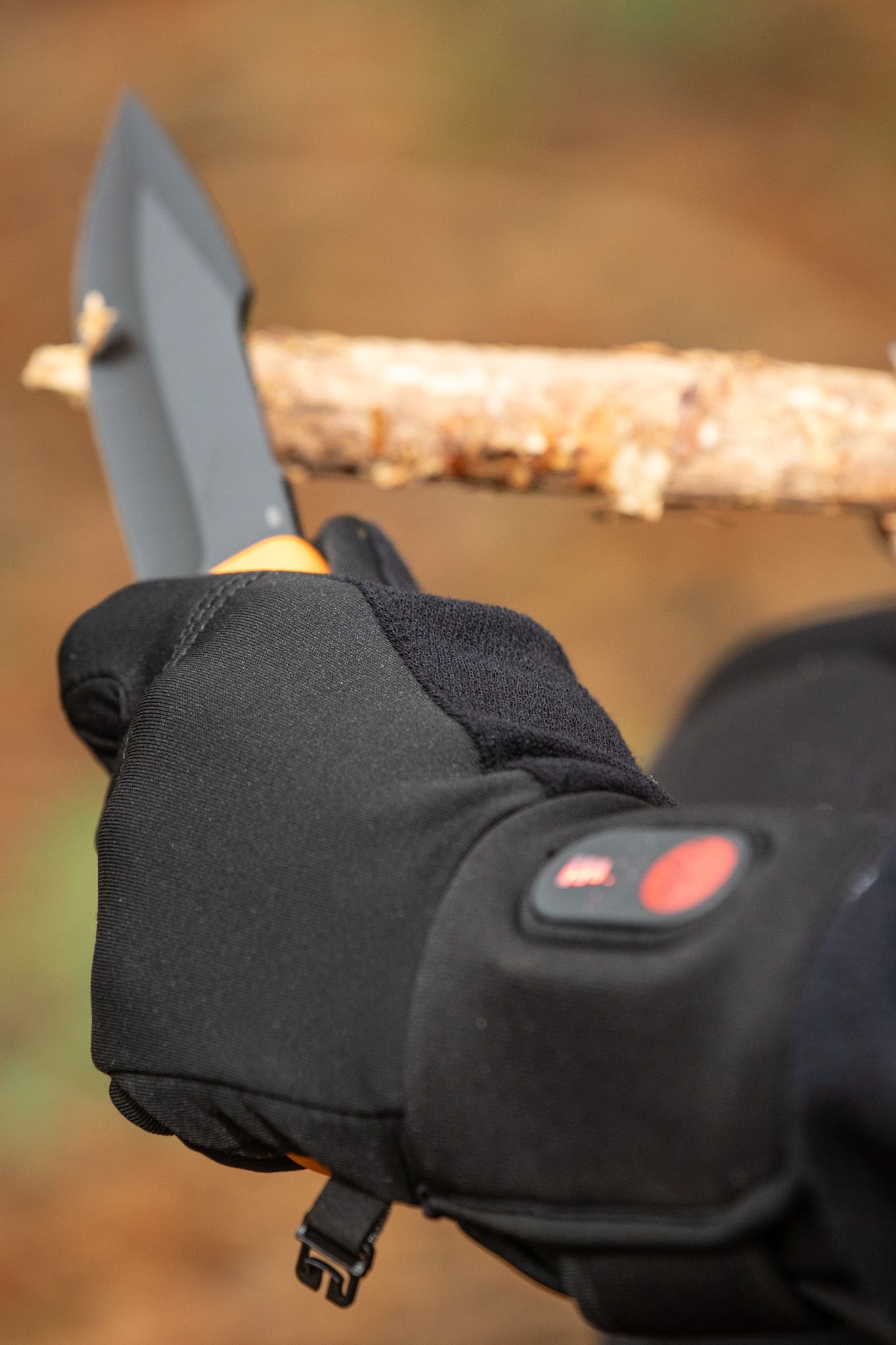Rider gripping motorcycle handlebars while wearing heated protective gloves in cold weather